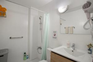 a white bathroom with a shower and a sink at Apartamento Danoe 4 in Mogán +13 photos