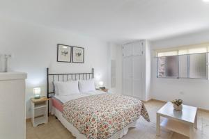 a white bedroom with a bed and a window at Apartamento Danoe 4 in Mogán