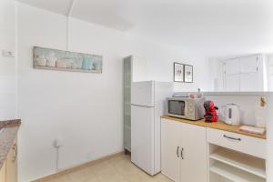 a kitchen with white cabinets and a microwave on a counter at Apartamento Danoe 4 in Mogán