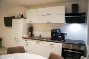 a kitchen with white cabinets and a sink at Ferienwohnung in Pfullendorf