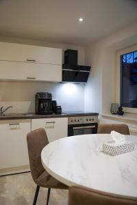 a kitchen with a white table and chairs and a stove at Ferienwohnung in Pfullendorf +11 photos
