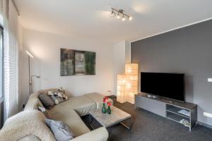 a living room with a couch and a flat screen tv at Heike in Willich