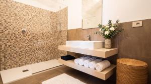 a bathroom with a sink and a mirror and towels at Edoardo Historic House in Gubbio +12 photos