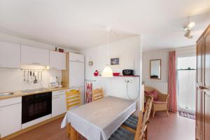 a kitchen with a table and a dining room at Möve Aba Bungalow 62 in Rerik