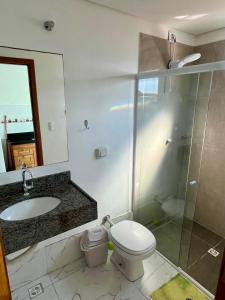 a bathroom with a toilet and a sink and a shower at Residencial Esmeralda-Vista ao Mar in Palhoça +34 photos
