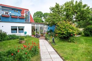 a house with a garden with red flowers at Möve Aba Bungalow 62 in Rerik