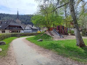 a dirt road with a playground in a park at Les Papillons in Tennenbronn