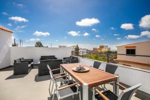 a patio with a wooden table and chairs on a balcony at Oramas Secret Cellar – Casa Rural in Arico