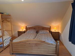 a bedroom with a wooden bed and two night stands at Les Papillons in Tennenbronn +26 photos