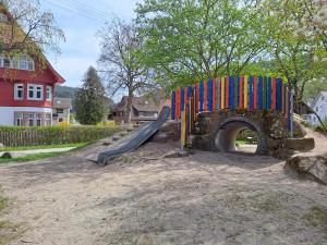 a playground with a slide in front of a tunnel at Les Papillons in Tennenbronn
