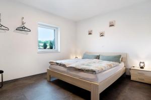 a bed in a white room with a window at Speicherhäuschen Maike in Geeste