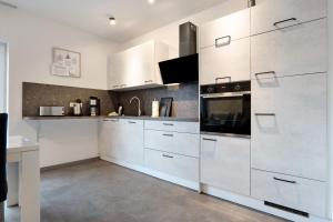 a kitchen with white cabinets and a stove at Speicherhäuschen Maike in Geeste