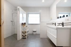 a white bathroom with a sink and a toilet at Speicherhäuschen Maike in Geeste +14 photos