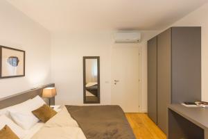 a small bedroom with a bed and a mirror at Villa Minerva in Lazise