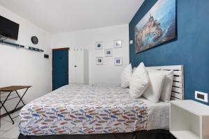 a bedroom with a bed with a blue wall at Ca Du Grifun 2 in Vernazza