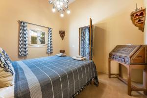 a bedroom with a bed and a table and a window at El Palomar in Santanyi +21 photos