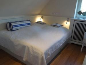 a white bed with two pillows on top of it at Sylthus-Haithabu in Wenningstedt