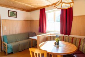 a living room with a table and a couch at Knollgut Ferienwohnung Buchberg in Goldegg