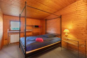 a bedroom with a bed in a wooden room at Holzhaus Grimm in Fedderingen