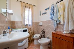 a bathroom with a white sink and a toilet at Casa Michela in Viddalba +14 photos