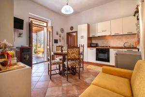 a kitchen and living room with a couch and a table at Casa Michela in Viddalba