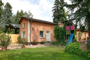 a house with a blue slide in front of it at Ferienhäuschen am See in Bestensee