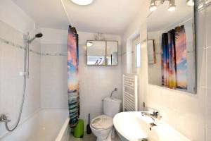 a white bathroom with a sink and a toilet at Ferienhäuschen am See in Bestensee +27 photos