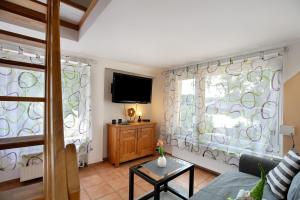 a living room with a couch and a tv at Ferienhäuschen am See in Bestensee