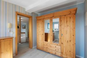 a room with a wooden cabinet and a bathroom at Ferienhaus Jasmin in Neuruppin