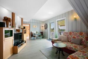 a living room with a couch and a tv at Ferienhaus Jasmin in Neuruppin