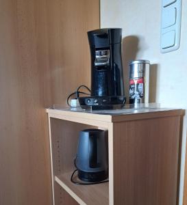 a coffee maker on a shelf in a hotel room at Pension Andrea in Herbstein +12 photos