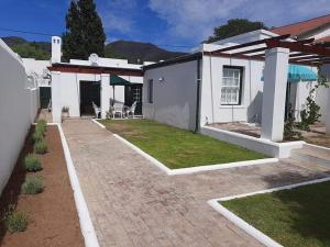 a house with a brick walkway in the yard at De Kothuize 7 in Graaff-Reinet