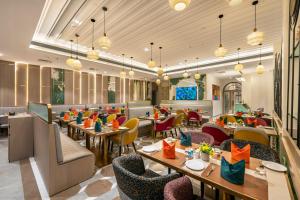 a dining room with tables and chairs and tablesktop at Lords Inn Somnath in Somnath