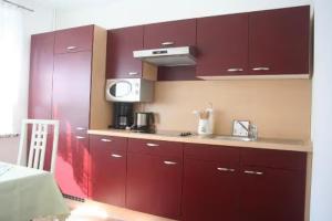 a kitchen with red cabinets and a sink at Apartment für 3, nicht für Monteure in Niederau