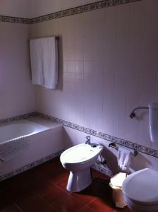 W łazience znajduje się toaleta, wanna i umywalka. w obiekcie Olhos do Mar w Albufeirze