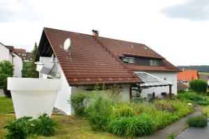 a house with a red roof and a garden at Ferienwohnung Marie in Niedereschach