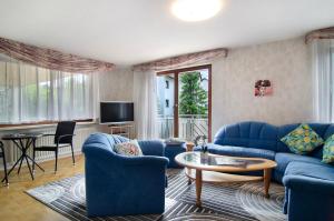 a living room with blue couches and a table at Ferienwohnung Marie in Niedereschach