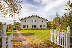 a white picket fence in front of a house at Ferienwohnungen Kämpenberg in Dingen