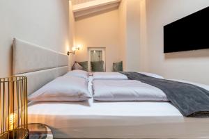 a bedroom with three beds with a flat screen tv at Cavalino Boutique 2 in Cavaion Veronese