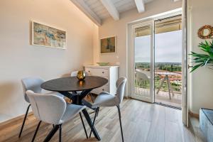a dining room with a table and chairs and a balcony at Cavalino Boutique 2 in Cavaion Veronese