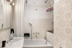 a white bathroom with a tub and a sink at Courmayeur 3V21 in Courmayeur +18 photos