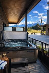 a hot tub on a deck with a view of the mountains at Ripper Retreat in Revelstoke