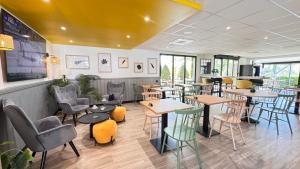 a restaurant with tables and chairs in a room at Campanile L'Isle d'Abeau - Bourgoin Jallieu in LʼIsle-dʼAbeau