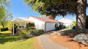 a house with a tree and a walkway at Campanile L'Isle d'Abeau - Bourgoin Jallieu in LʼIsle-dʼAbeau