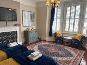 a bedroom with two beds and a rug at Gyves House in Eastbourne