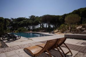 a swimming pool with chairs and a swimming poolvisor at Forest Village T2 in Mindel