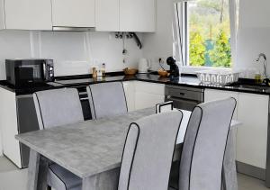 a kitchen with a table with chairs and a microwave at Forest Village T2 in Mindel