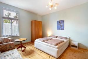 a bedroom with a bed and a couch and a window at Haus Meistereck Melzow in Melzow