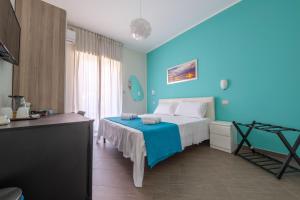 a blue bedroom with a bed and a table at Paladino in Giardini Naxos