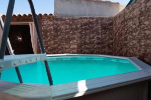 an empty swimming pool with two chairs around it at Casa Rural Los Enebros in Los Navalucillos